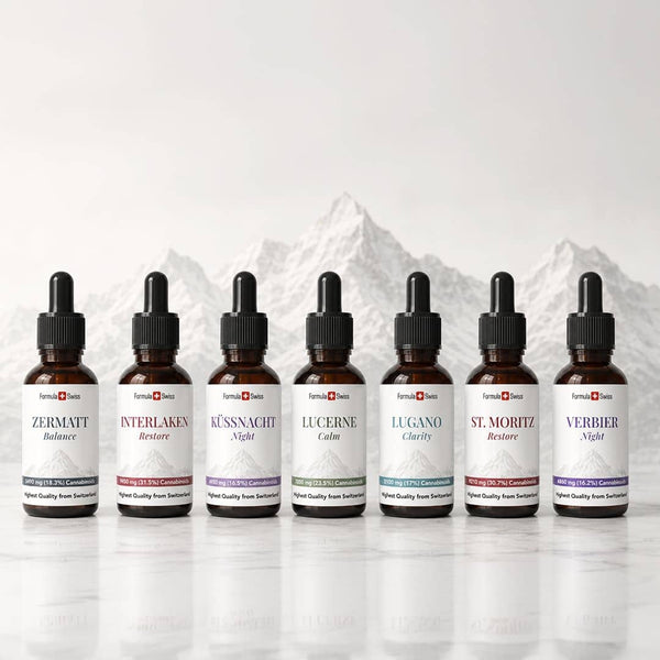 Coleção de óleo Formula Swiss CBD com sete garrafas de conta-gotas de âmbar exibidas em frente a um fundo de montanha suíço.